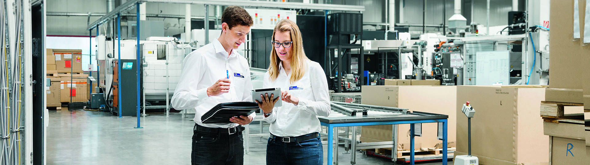 Two young FUCHS employees standing togther at a production site 